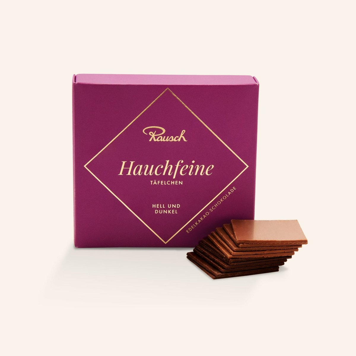 Elegante violette Schachtel "Rausch Hauchfeine Täfelchen" mit gestapelten dünnen Schokoladentäfelchen hell und dunkel.