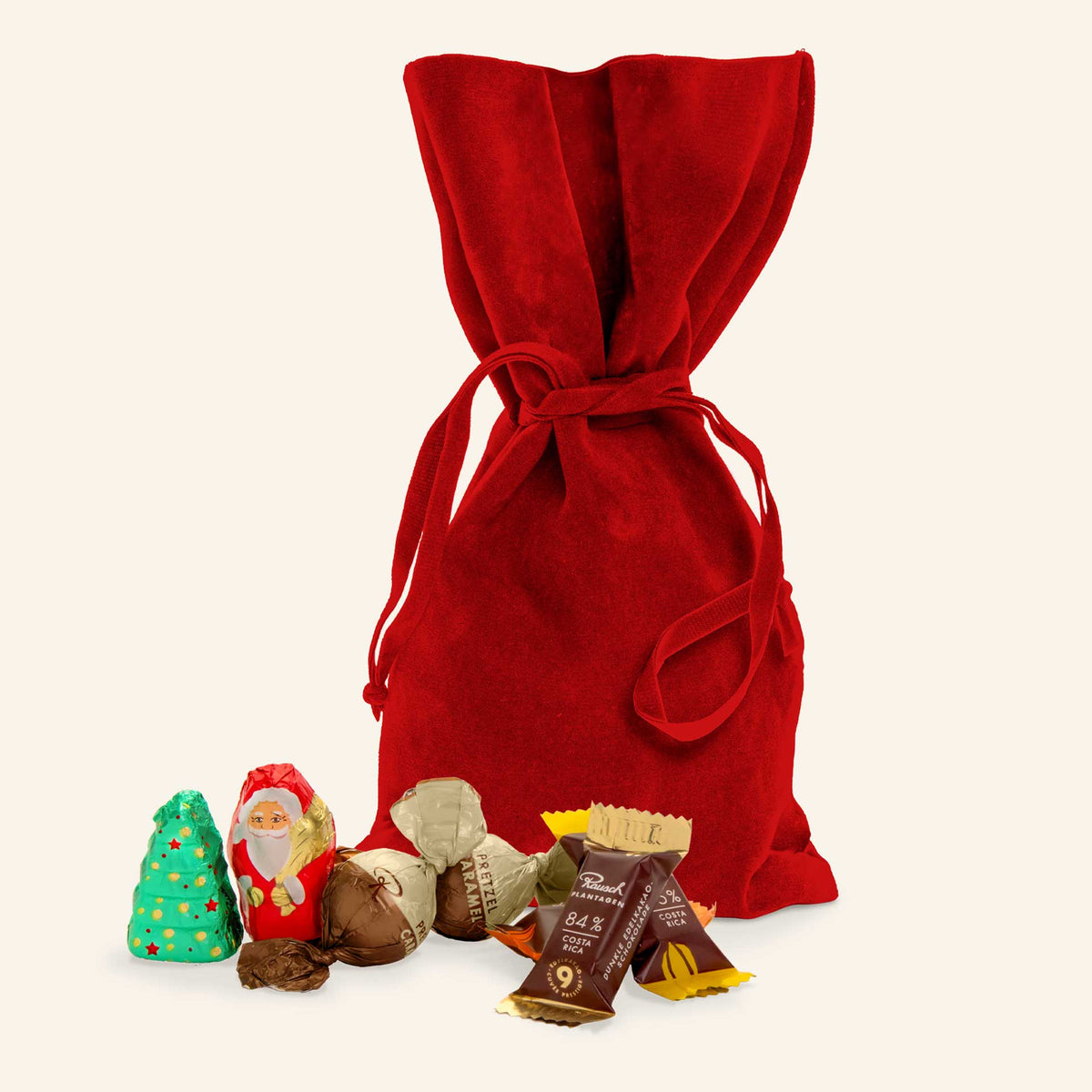Rotes Samtsäckchen mit Schokofiguren: Weihnachtsbaum, Nikolaus und Rausch Brezel-Karamell-Pralinen.