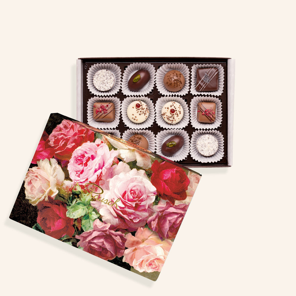 Pralinenschachtel mit Rosenmotiv, enthält zwölf helle und dunkle Pralinen in einer offenen Verpackung.