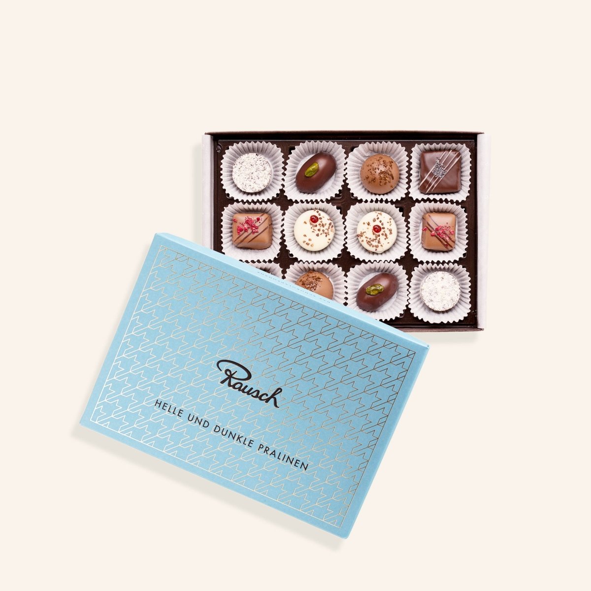Elegante Box mit 12 hellen und dunklen Pralinen von Rausch, Pralinensortiment in blauem Karton.