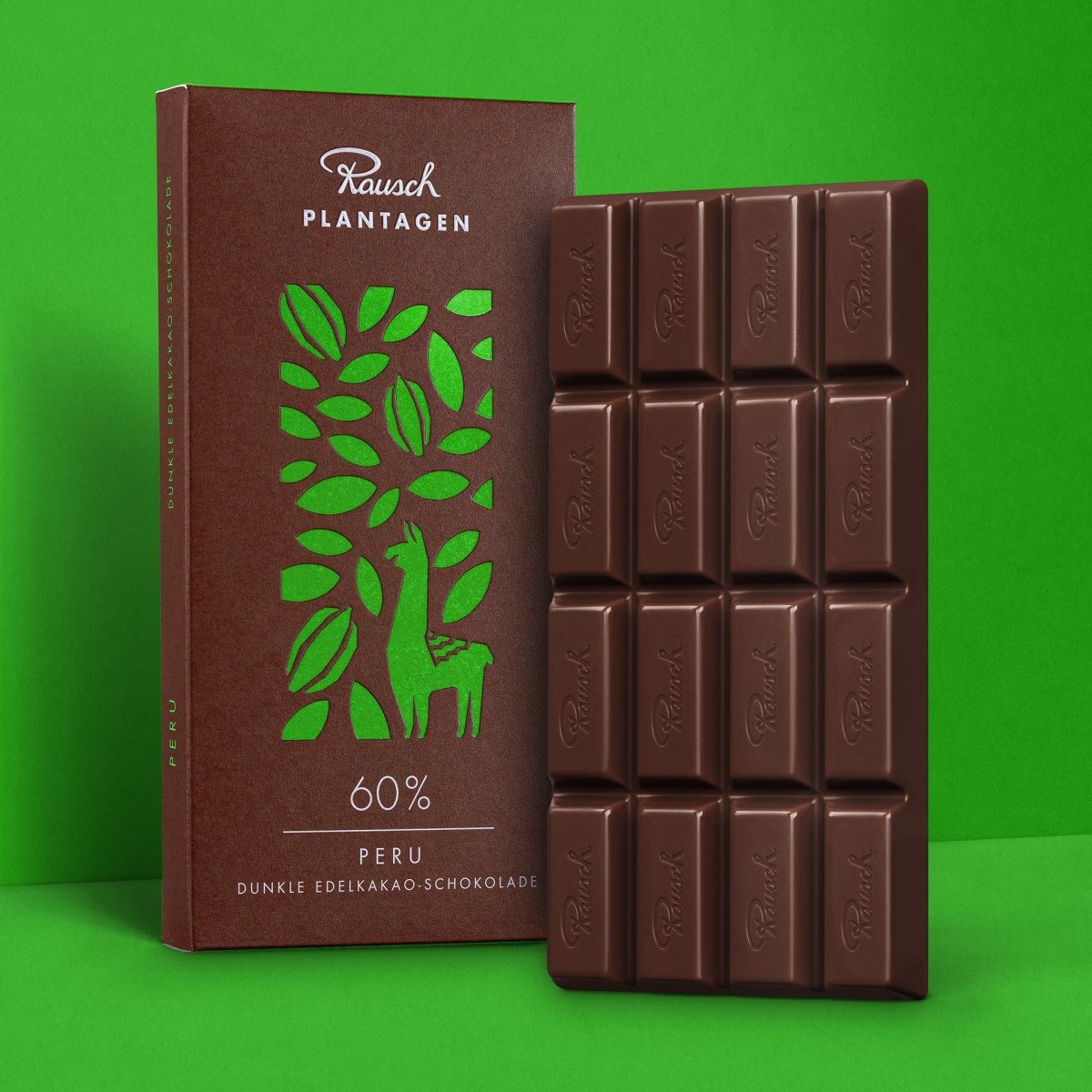 Rausch Schokoladentafel Peru 60% vor grünem Hintergrund, Verpackung mit Kakaobohnen und Lamamotiv.