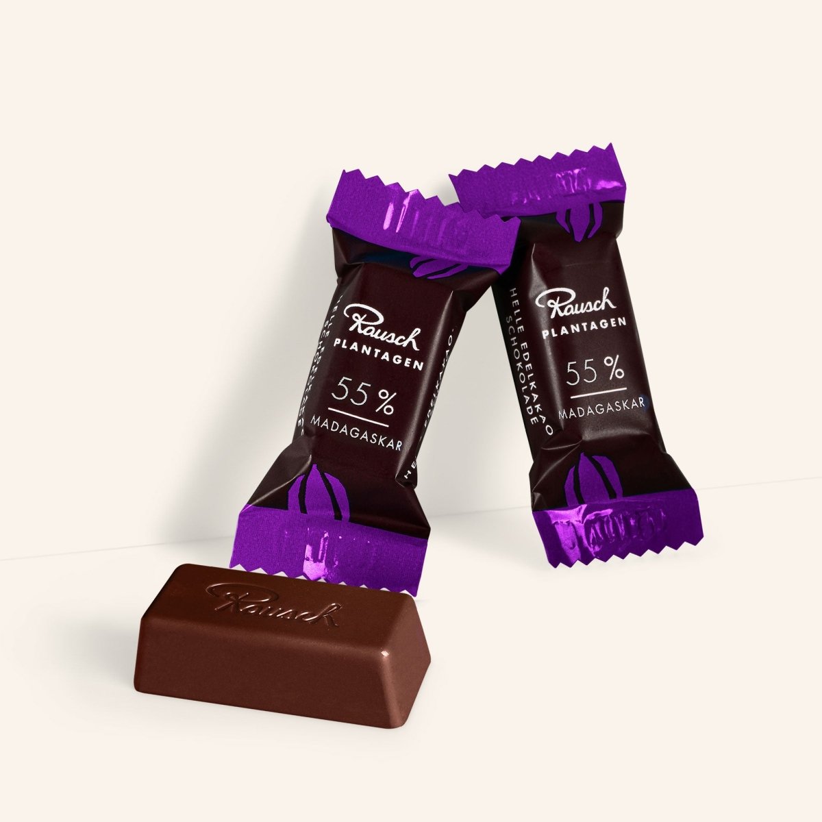 Zwei Rausch Plantagen-Minis, Madagaskar 55% Kakao, mit Lila-Verpackung, ein Mini ausgepackt.