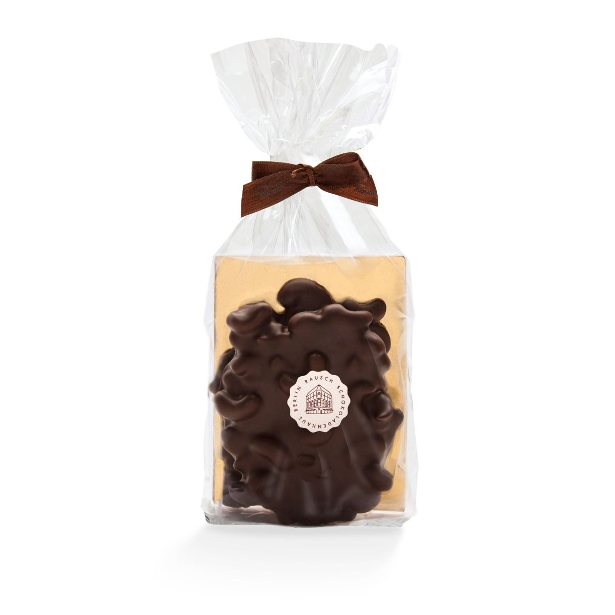 Verpackte Rausch Schokolade mit Cashew-Stücken, verziert mit brauner Schleife in transparenter Folie.