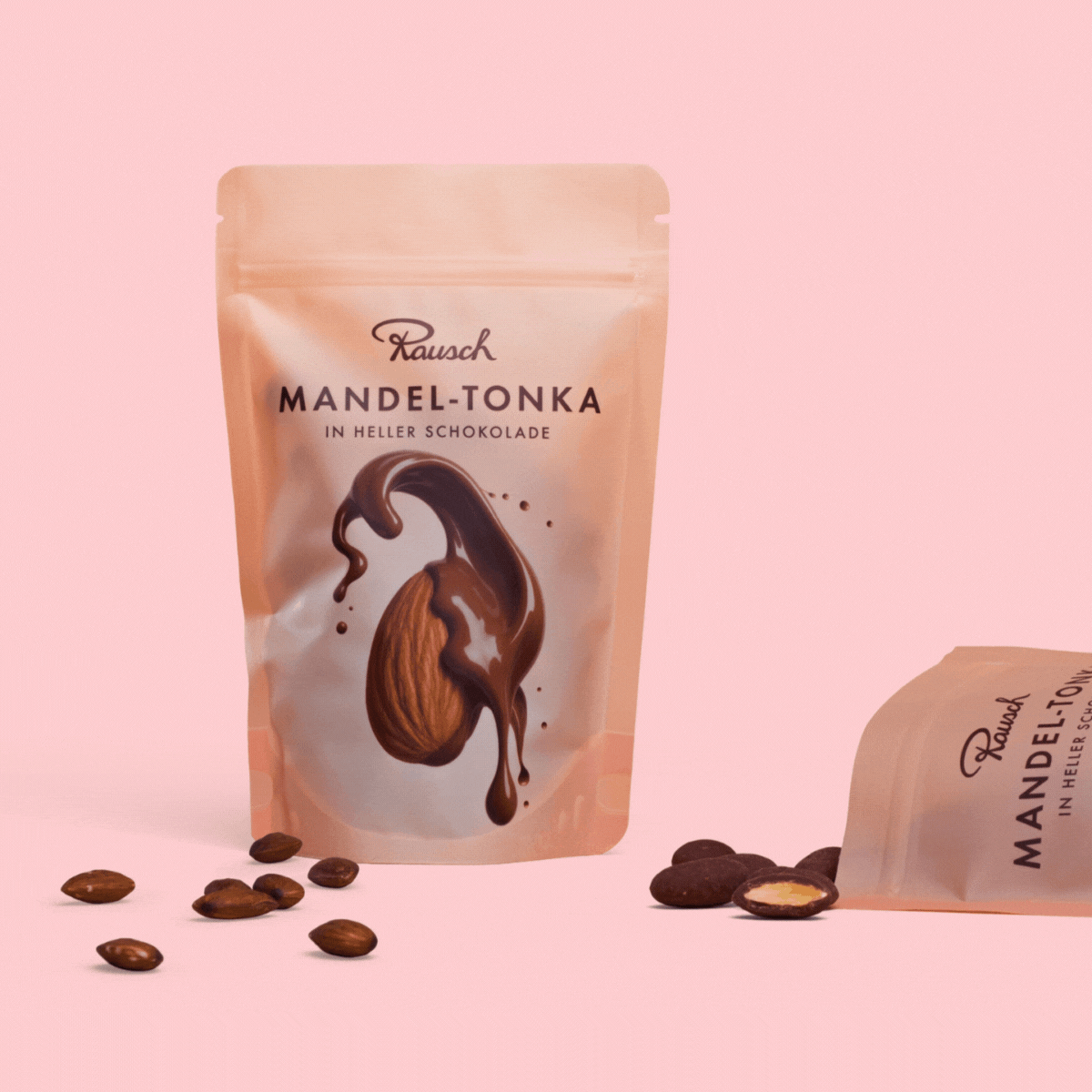 Rausch Mandel-Tonka in heller Schokolade, Verpackung mit Mandeln auf rosa Hintergrund.