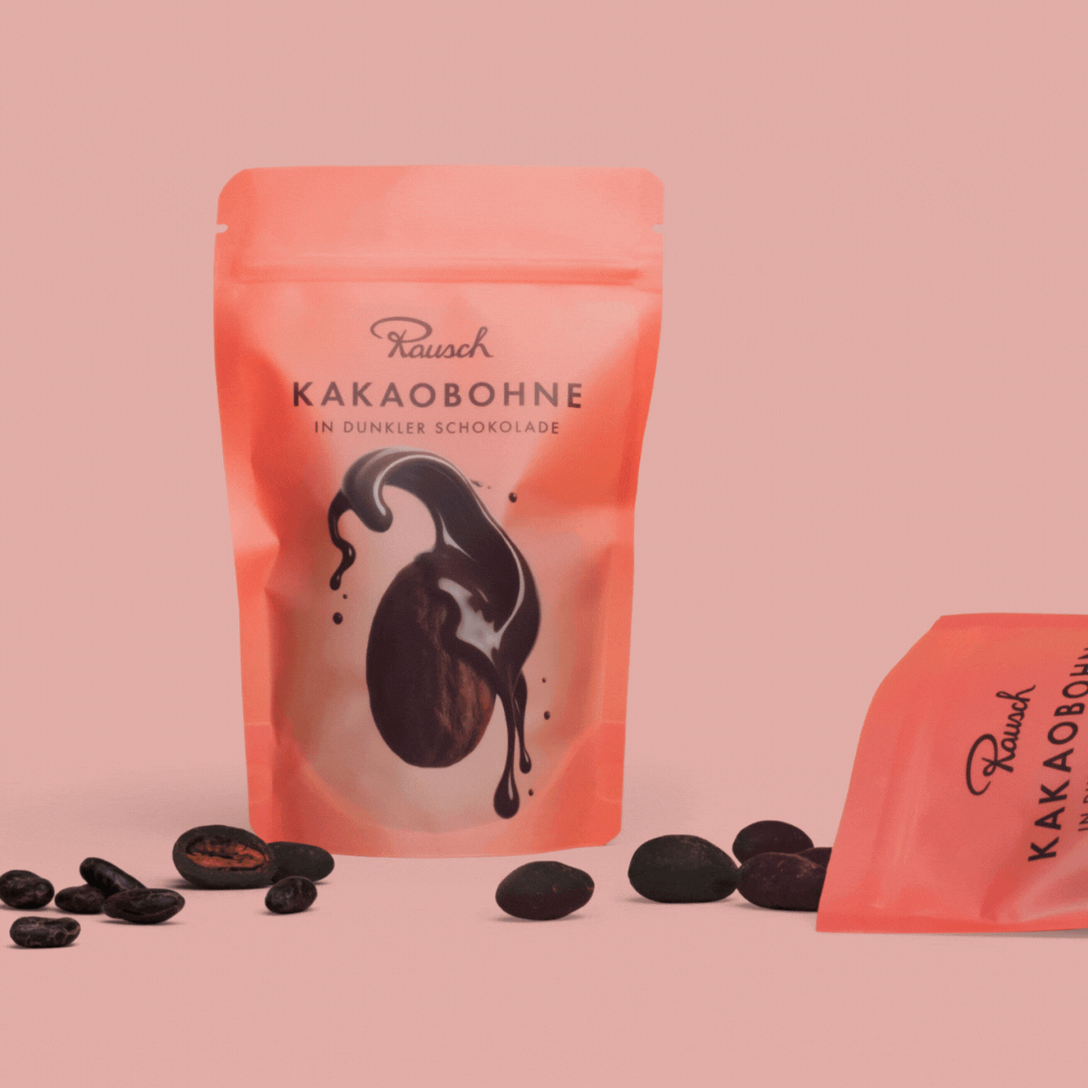 Rausch Verpackung mit Kakaobohnen in dunkler Schokolade vor rosa Hintergrund.