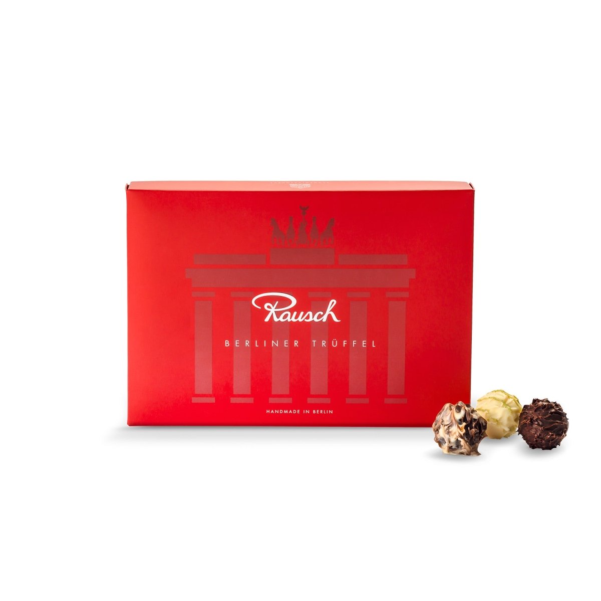 Rote Rausch-Verpackung mit Berliner Trüffel-Motiv, Brandenburger Tor-Logo, drei Pralinen daneben.