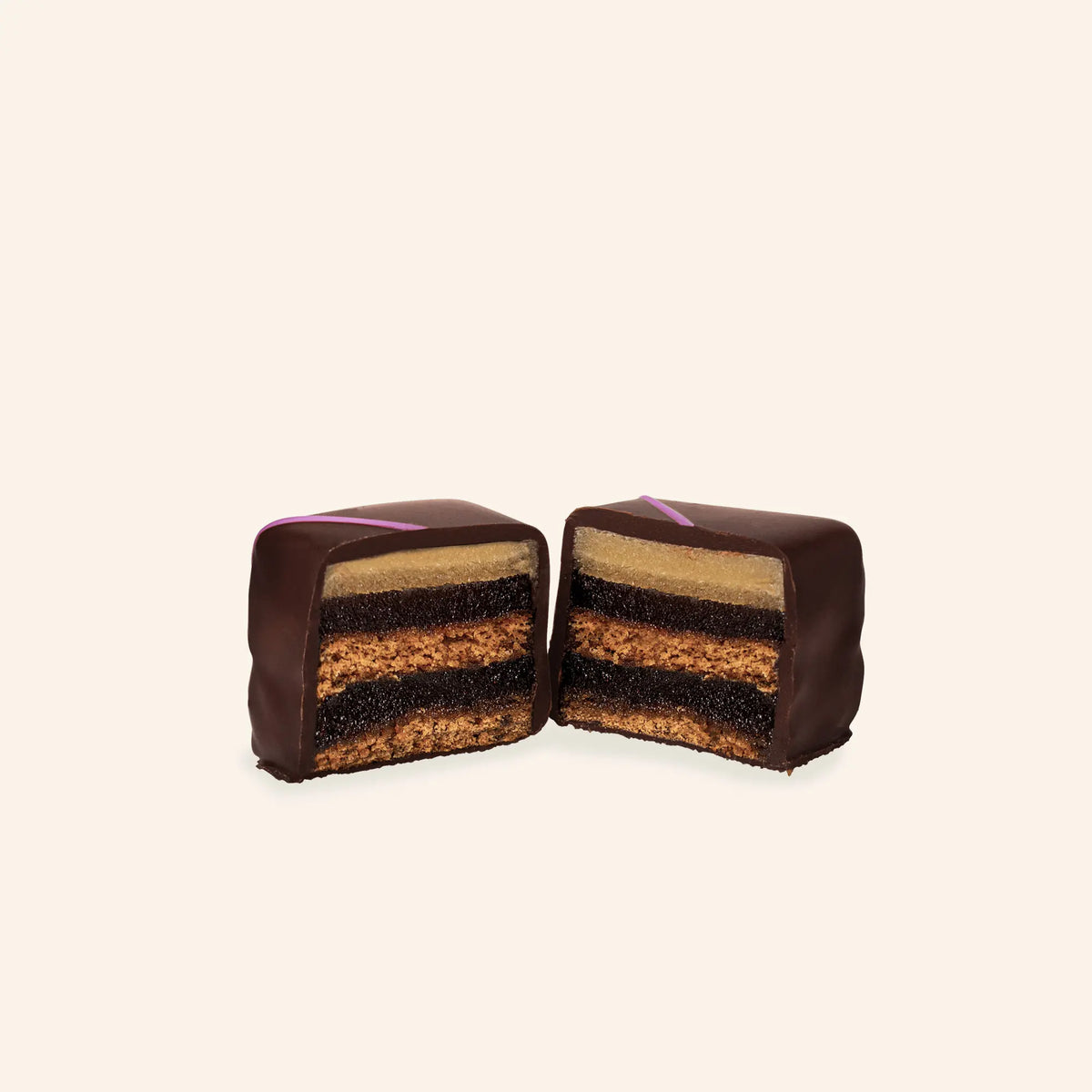 Aufgeschnittener Rausch Dominostein mit Schichten aus Lebkuchen, Fruchtgelee und Nougat, umhüllt von dunkler Schokolade.