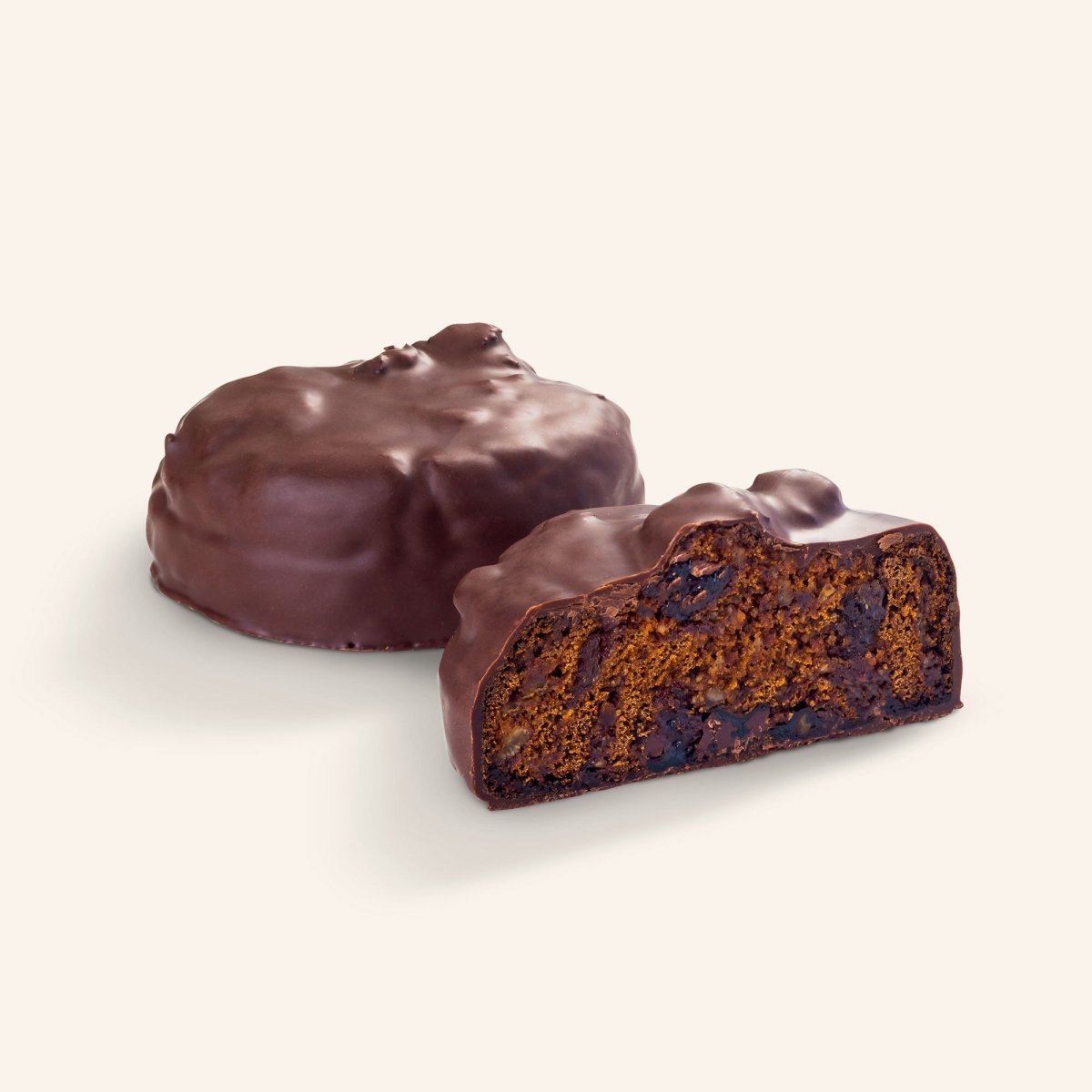Schokoladenüberzogene Lebkuchen mit Früchten und Nüssen, eine Bombe im Ganzen und eine angeschnitten.