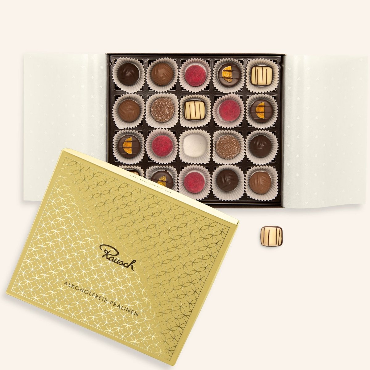 Offene Schachtel mit 20 alkoholfreien Pralinen, verschiedene Sorten und Farben, goldene Verpackung von Rausch.