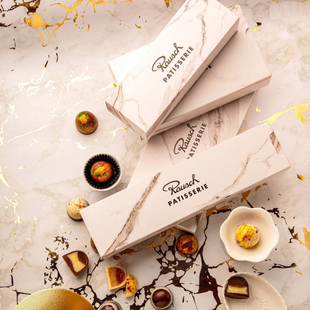 Handgemachte Patisserie Pralinen in weißer Box mit Marmoroptik. - Rausch