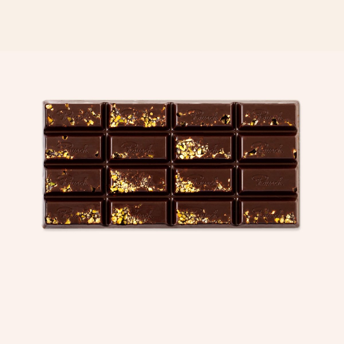 Dunkle Schokoladentafel mit goldenen Pistaziensplittern verziert.