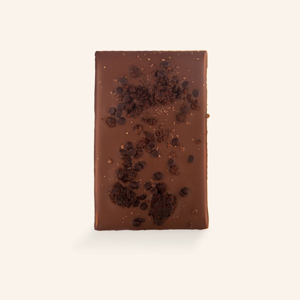 Unverpackter Triple Chocolate Brownie von Rausch mit Schokoladenstückchen und Krümeln auf heller Oberfläche.