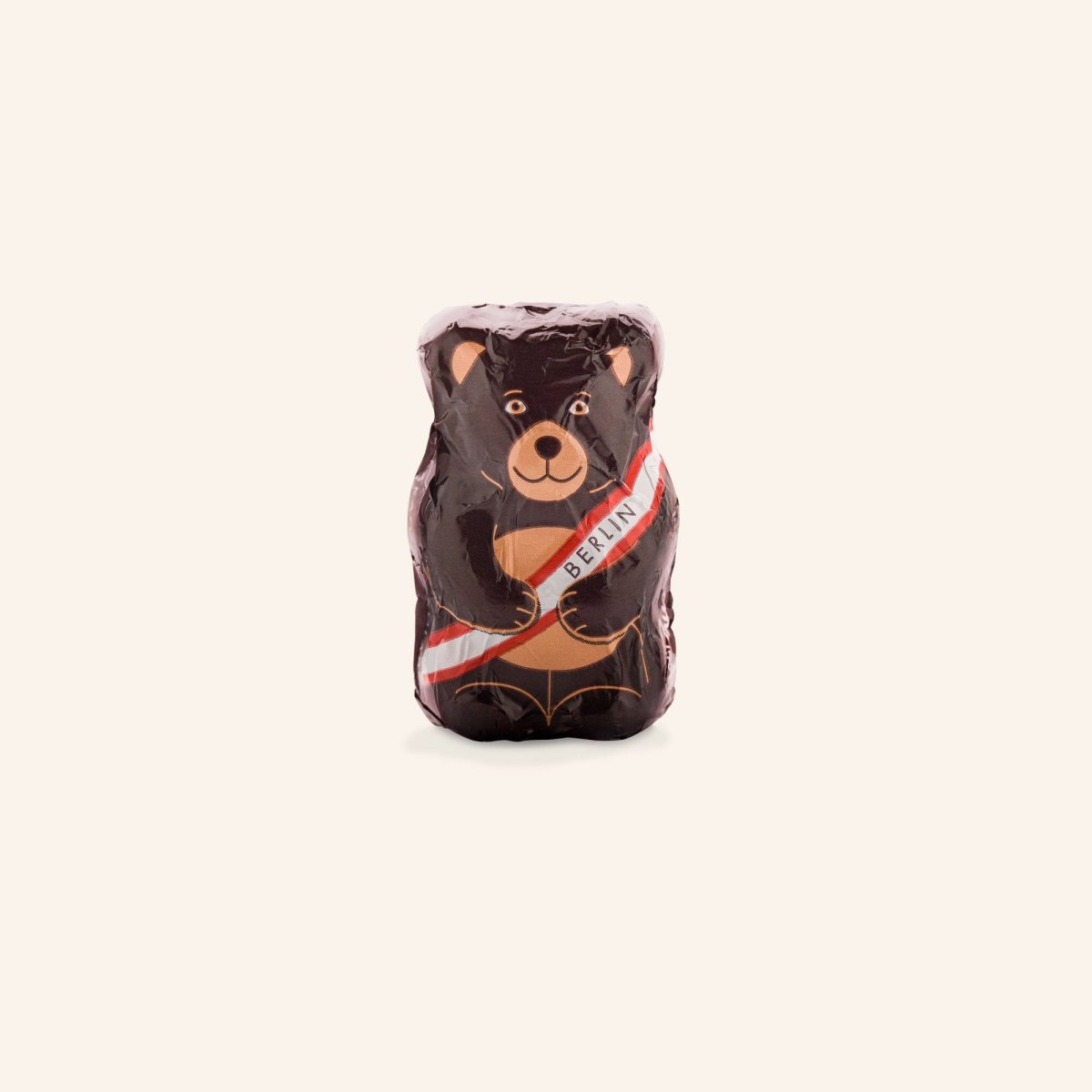 Schokoladenfigur eines Bären mit Berlin-Schärpe, in brauner Folie verpackt.