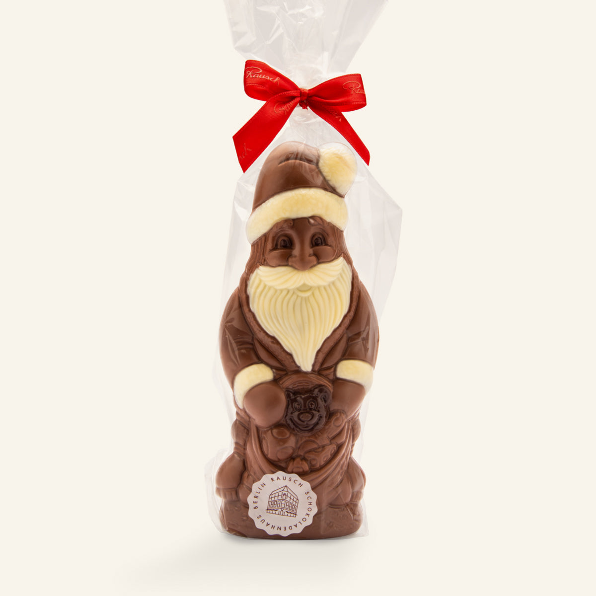 Großer handwerklicher Weihnachtsmann aus brauner und weißer Schokolade mit Geschenkbeutel und roter Schleife. - Rausch