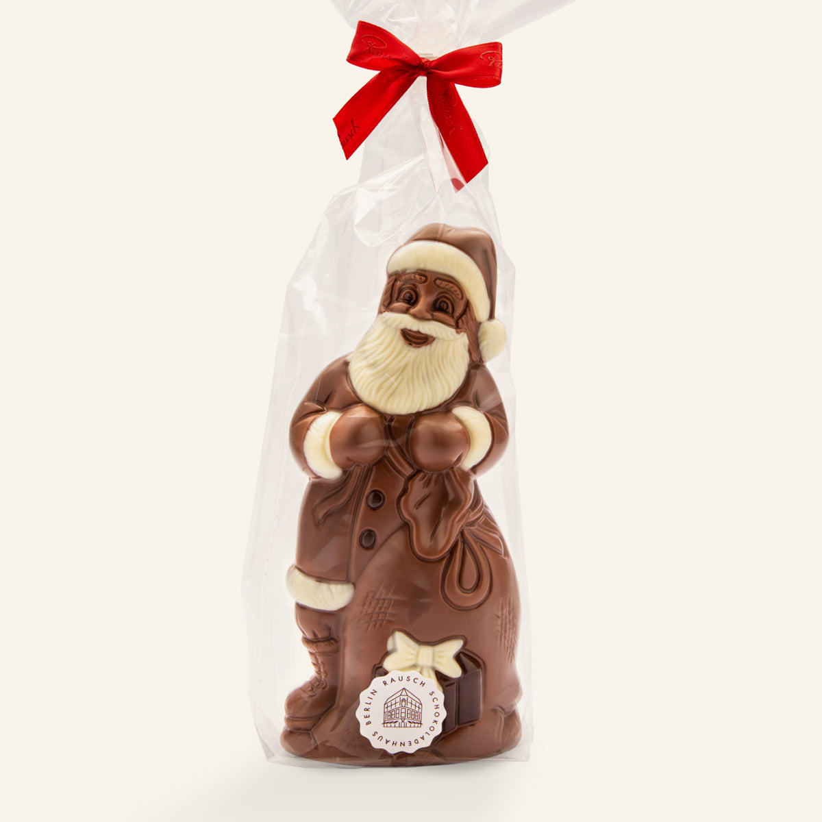 Hell- und dunkelbraune handwerkliche Schokoladenfigur Weihnachtsmann mit Sack und roter Schleife. - Rausch