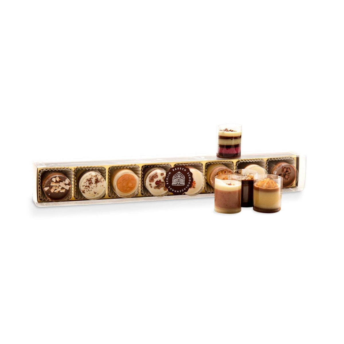 Elegante Petit Fours in durchsichtiger Box, dekorativ arrangiert.