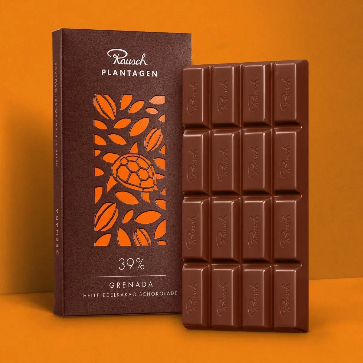 Rausch Grenada 39% Schokolade mit Verpackung und Tafel auf orangem Hintergrund.