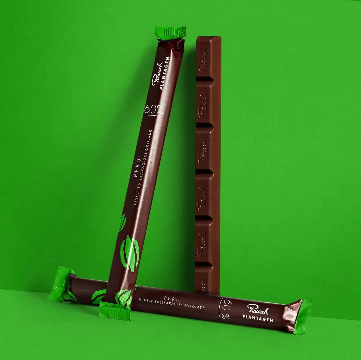 Dunkle Schokolade Peru 60% in grüner Verpackung vor grünem Hintergrund, schmaler Stickform.