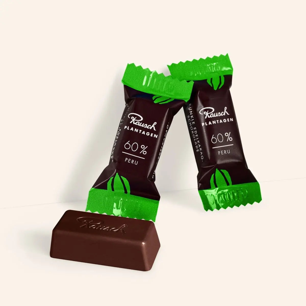 Zwei Schokoladenminis in grüner Verpackung, beschriftet mit Rausch Plantagen 60 % Peru.