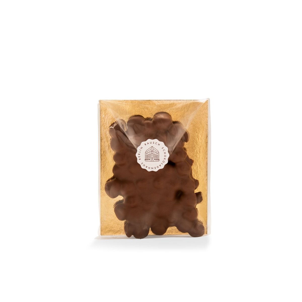Verpackte Tafel Milchschokolade mit Haselnüssen auf goldenem Hintergrund.