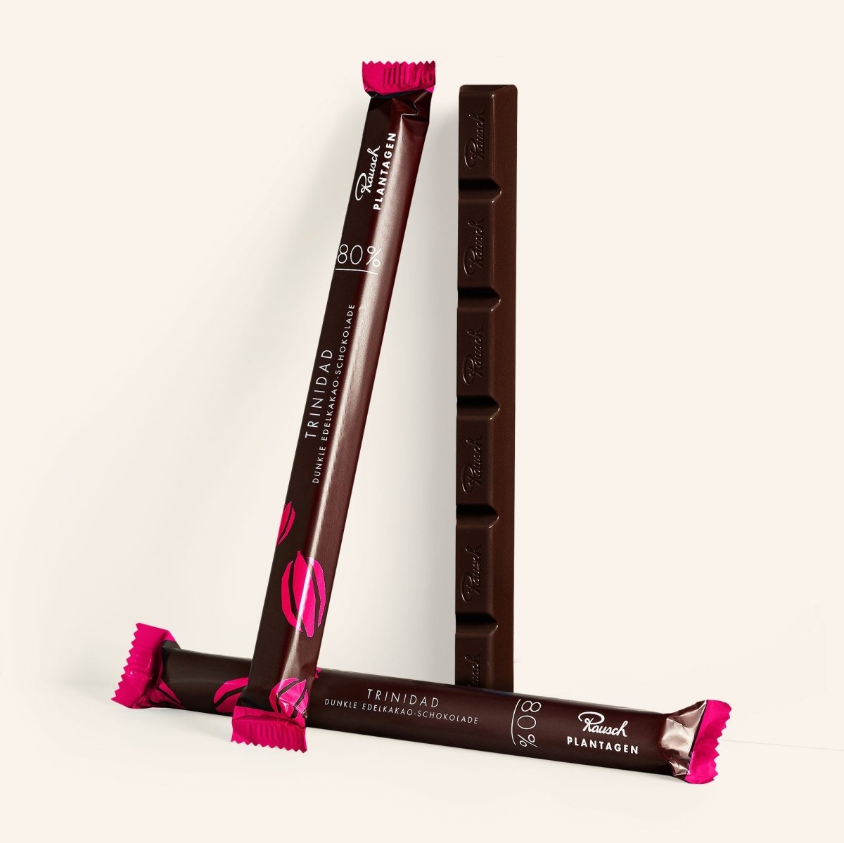 Rausch Trinidad 80% dunkle Schokolade Sticks vor hellem Hintergrund. Elegantes, modernes Design mit rosa Akzenten.