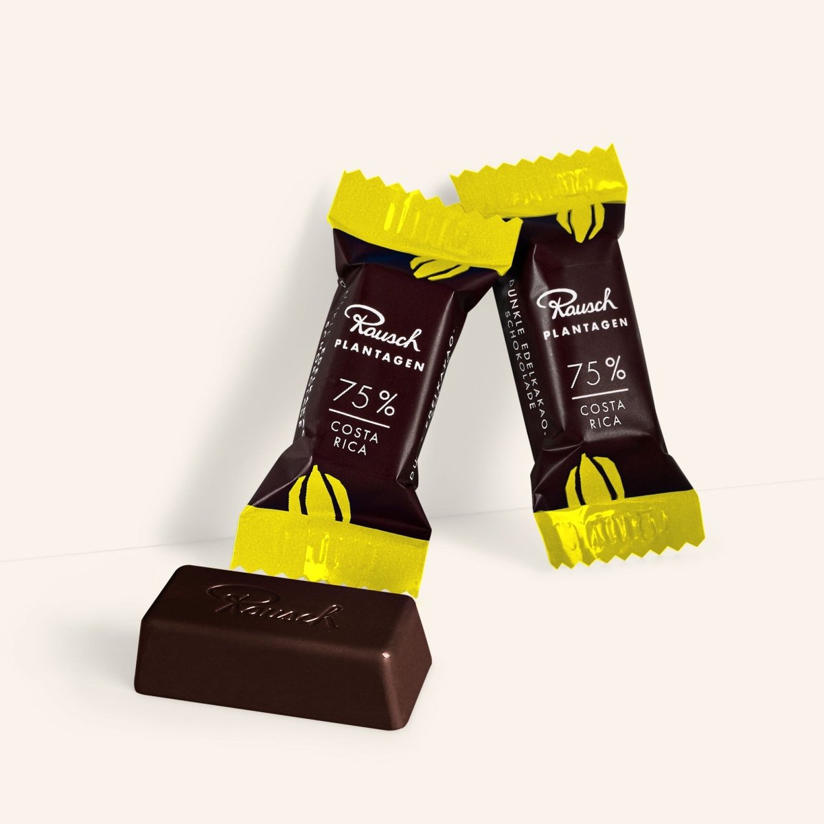 Zwei Rausch Costa Rica 75% Mini-Schokoladen mit gelbem und braunem Verpackungsdesign vor hellem Hintergrund.