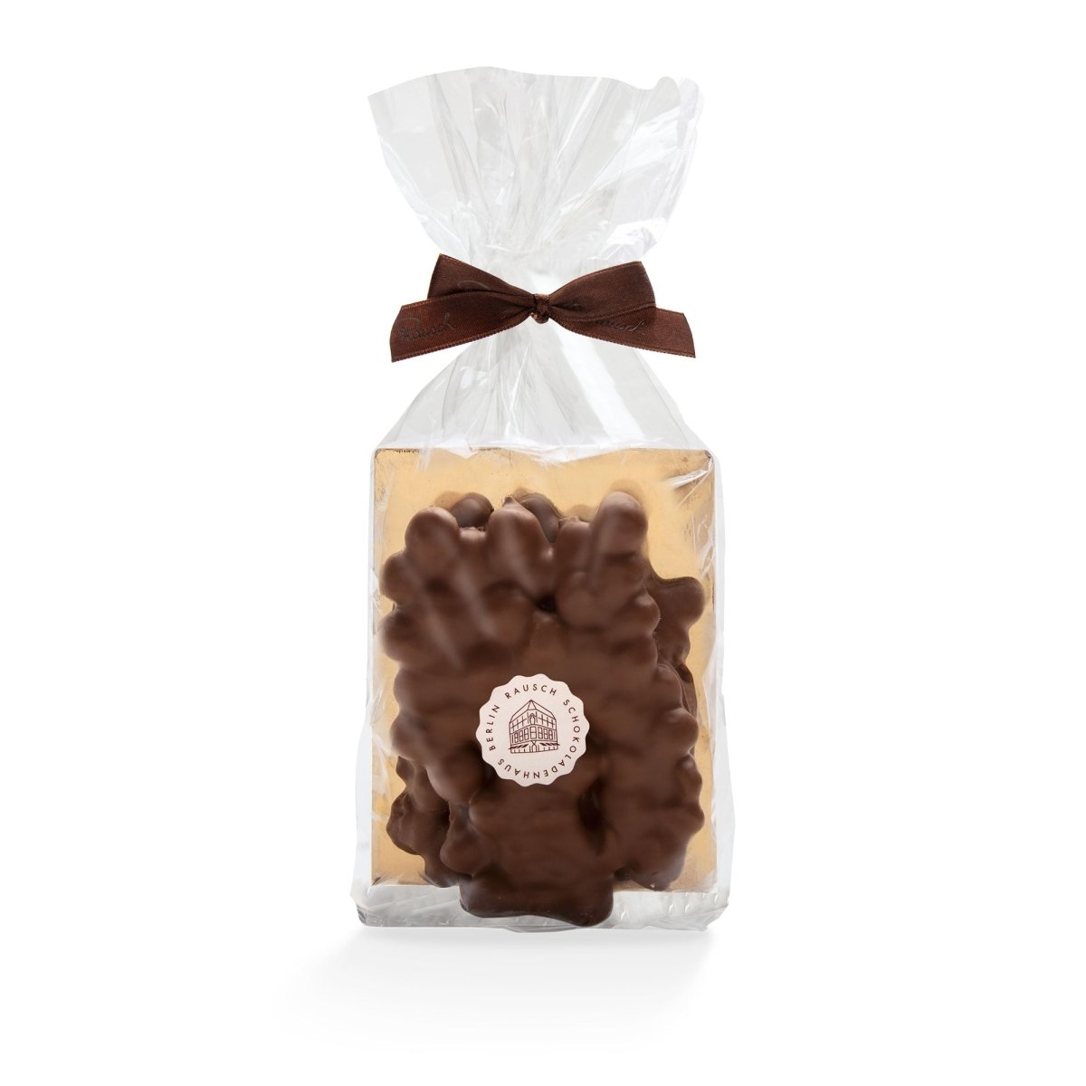 Verpackte Schokolade mit Haselnüssen, in durchsichtiger Folie mit brauner Schleife.