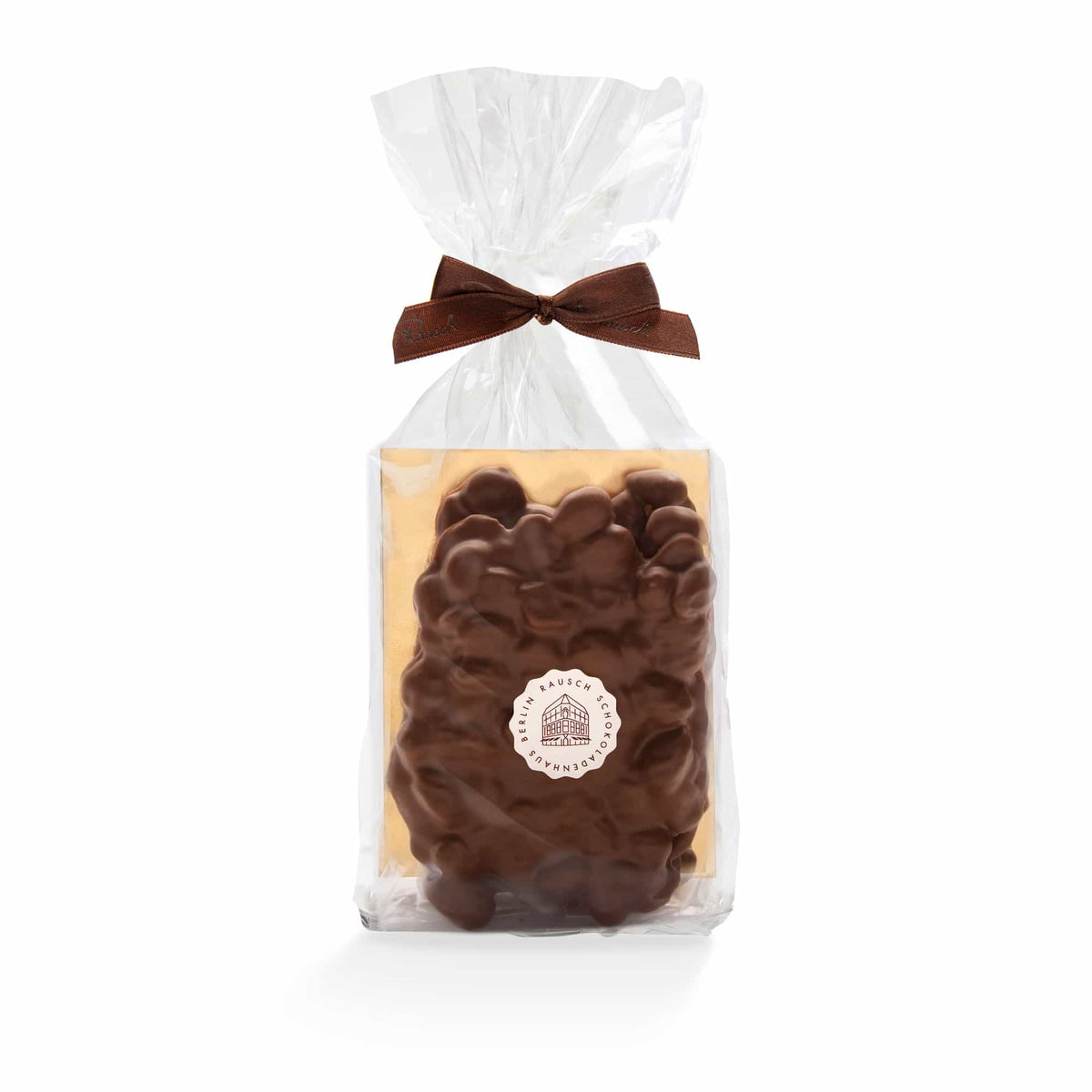 Verpackte Schokoladentafel mit Nüssen, dekoriert mit brauner Schleife, auf weißem Hintergrund.