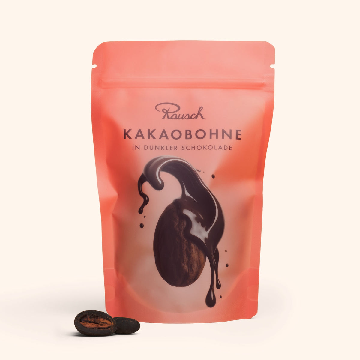 Verpackung von Rausch Kakaobohnen in dunkler Schokolade, rosa Tüte mit abgebildeter Kakaobohne.