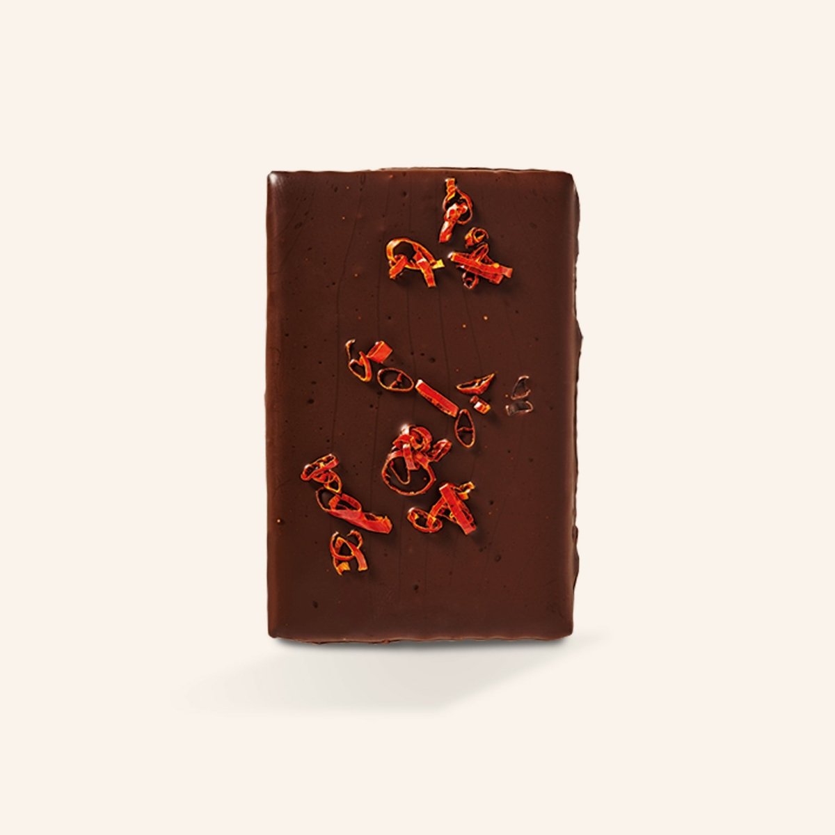 Tafel dunkler Schokolade mit Chilistückchen auf cremefarbenem Hintergrund.