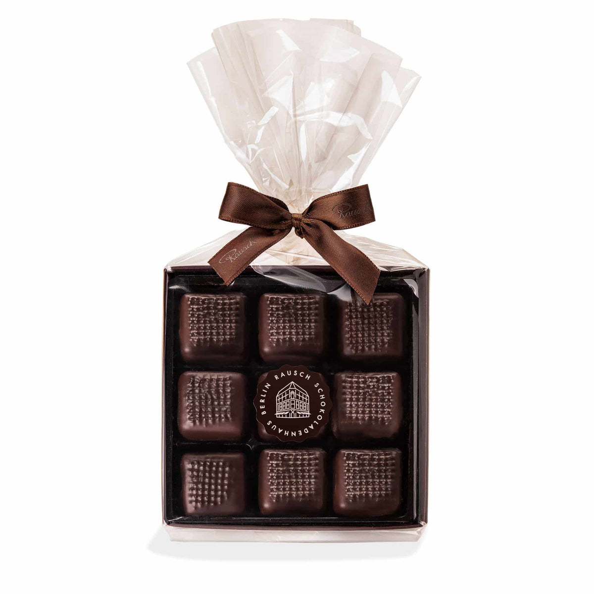 Verpackte Dominosteine von Rausch in eleganter Zellophanverpackung mit brauner Schleife.