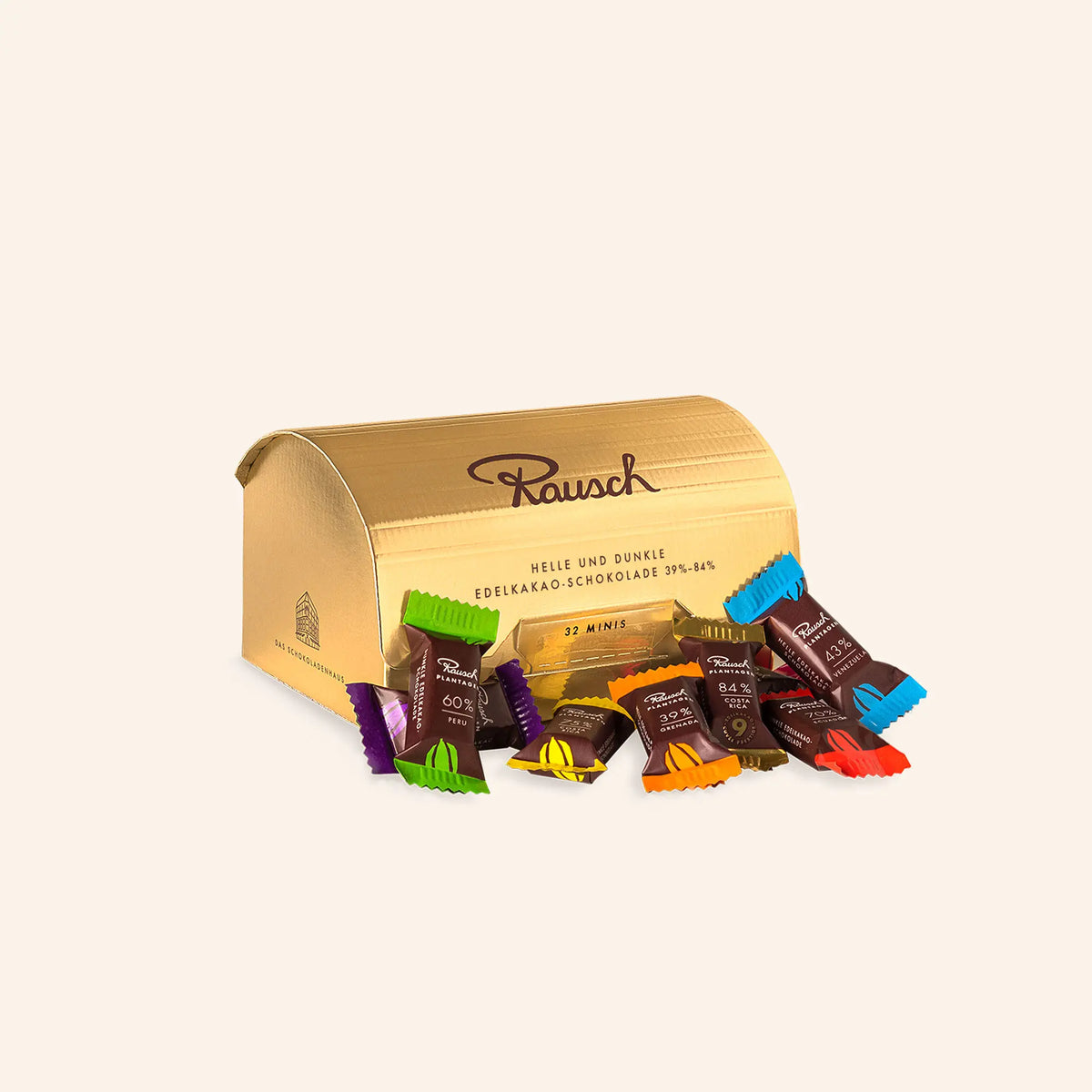 Goldfarbene Box von Rausch mit edlen Schokoladenminis in verschiedenen Sorten vor hellem Hintergrund.
