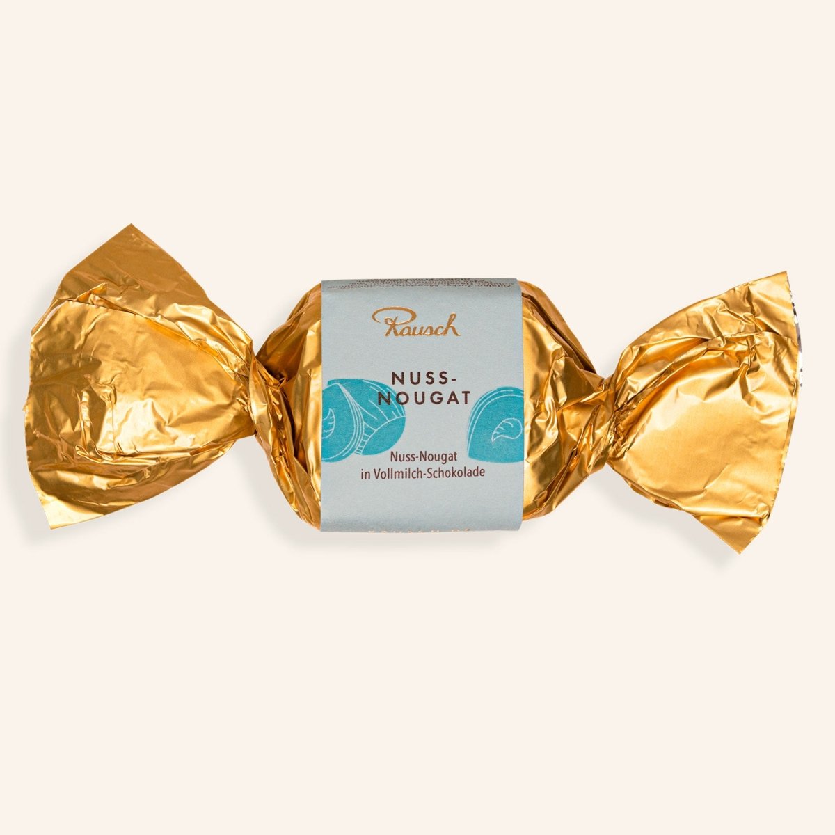 Goldene Verpackung eines Nuss-Nougat-Happens von Rausch, umhüllt von Vollmilchschokolade.