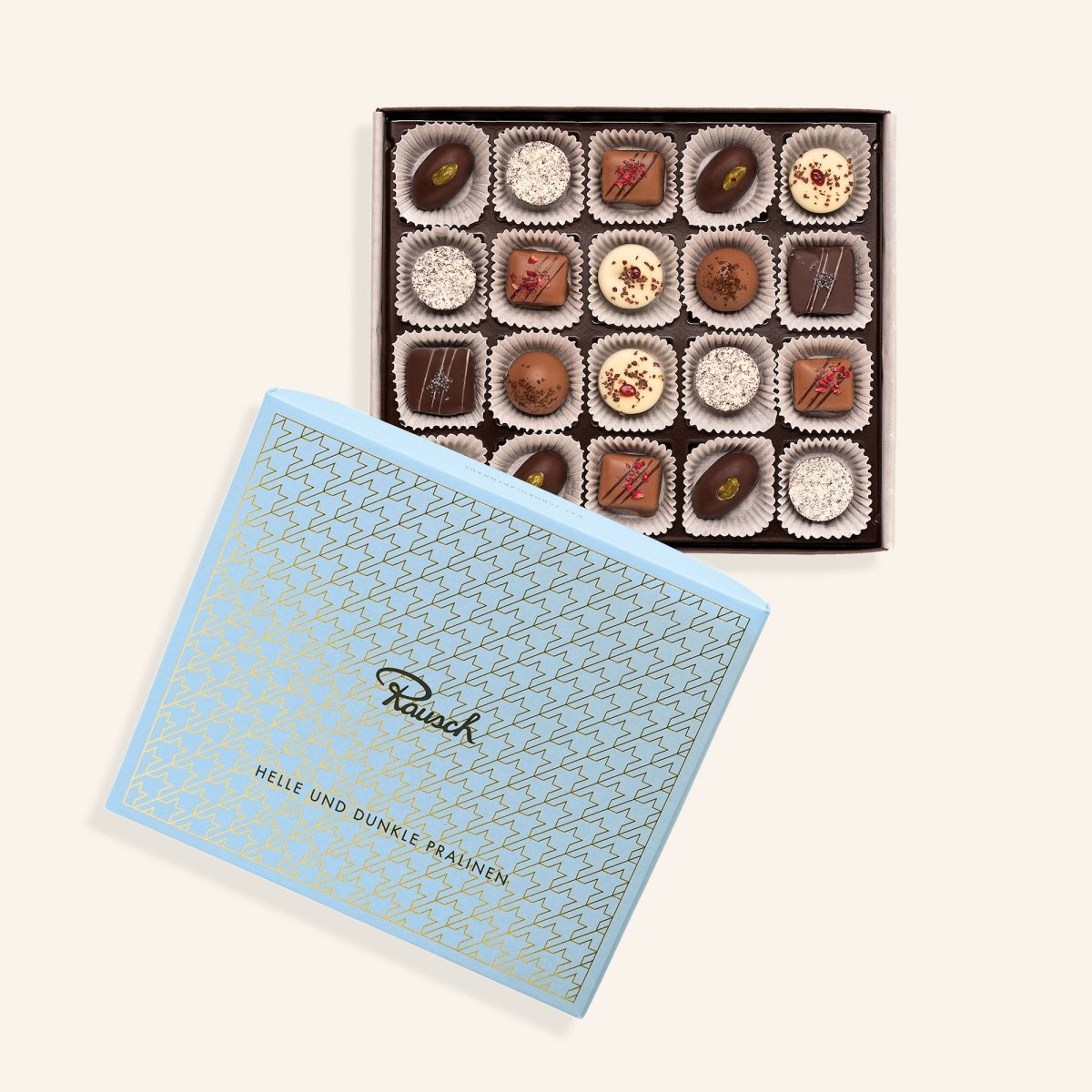 Offene Pralinenschachtel mit hellen und dunklen Pralinen, edles blaues Design von Rausch, Schokoladenhersteller.