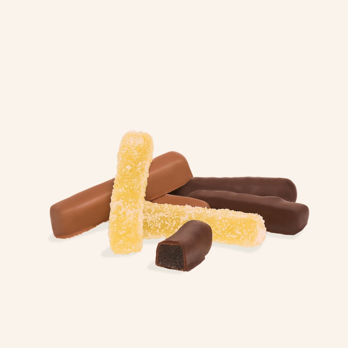 Kandierte Ingwerstücke teils mit dunkler, teils mit Milchschokolade überzogen vor hellem Hintergrund.