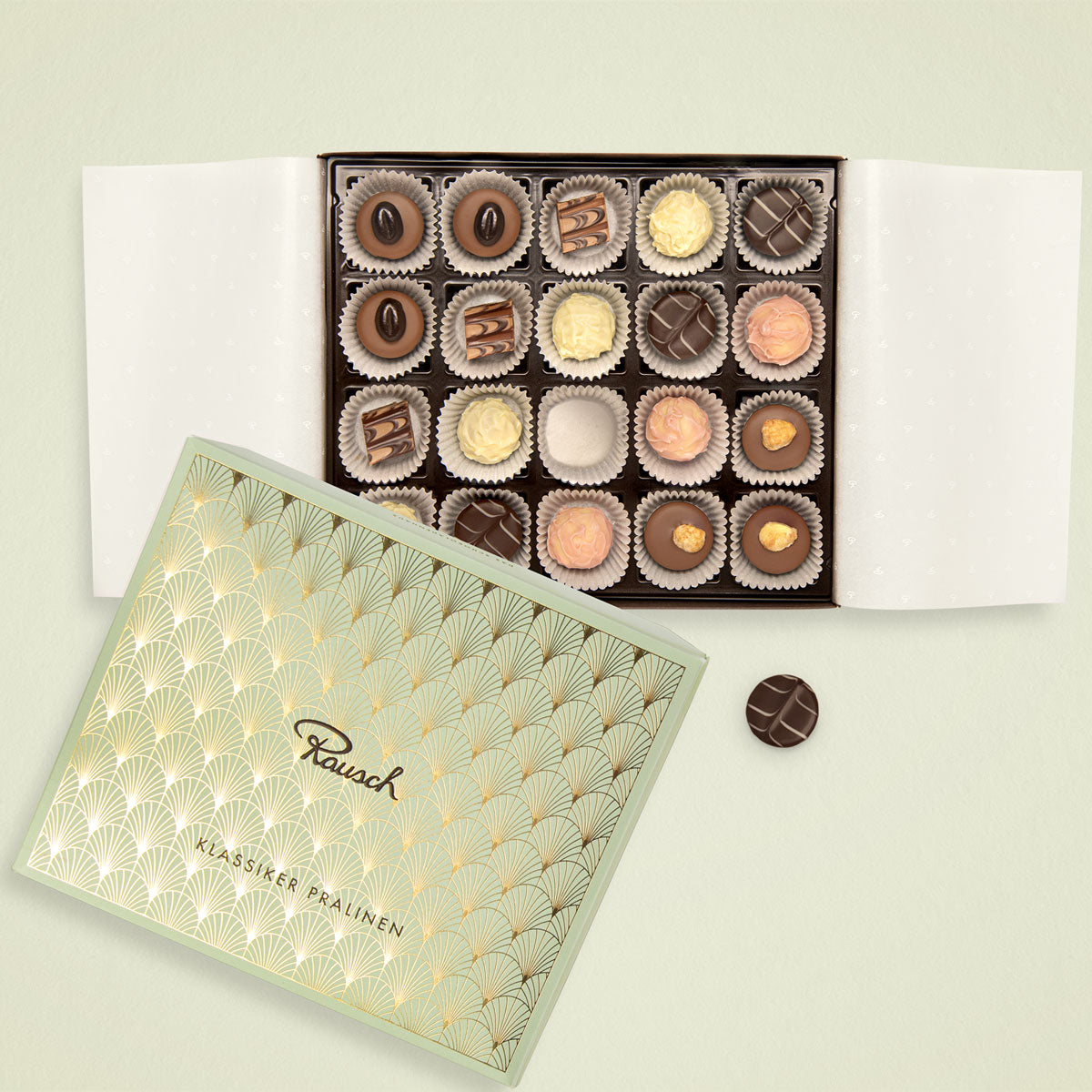 Geöffnete Pralinenschachtel mit 20 Pralinen in verschiedenen Sorten, Rausch-Logo auf der Verpackung, elegant präsentiert.