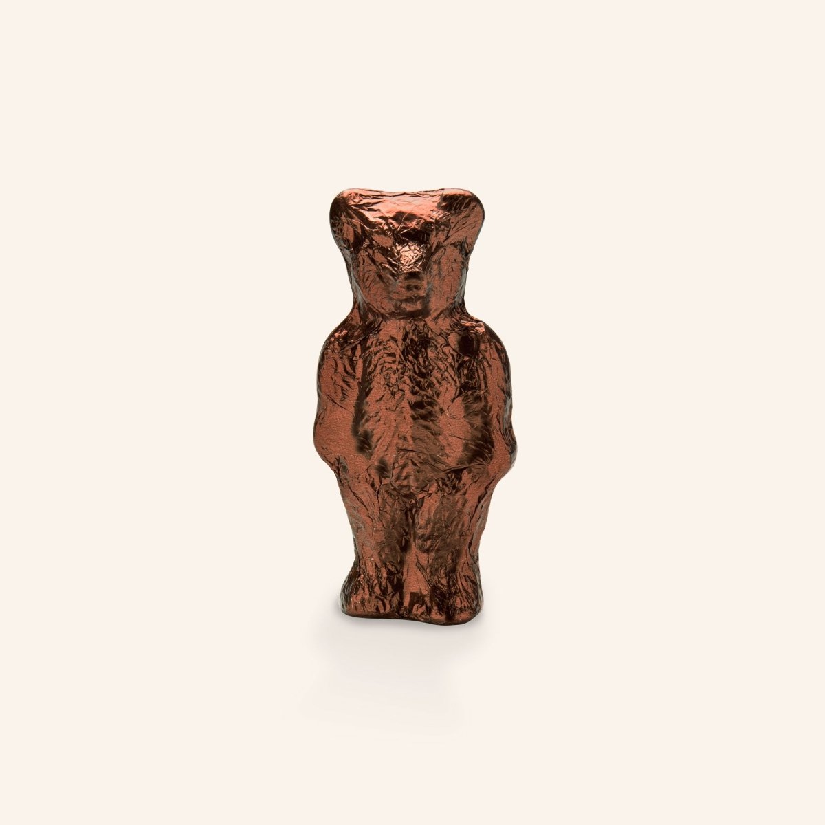 Brauner Schokoladenbär, glänzend verpackt in Folie, vor einem hellen Hintergrund präsentiert.