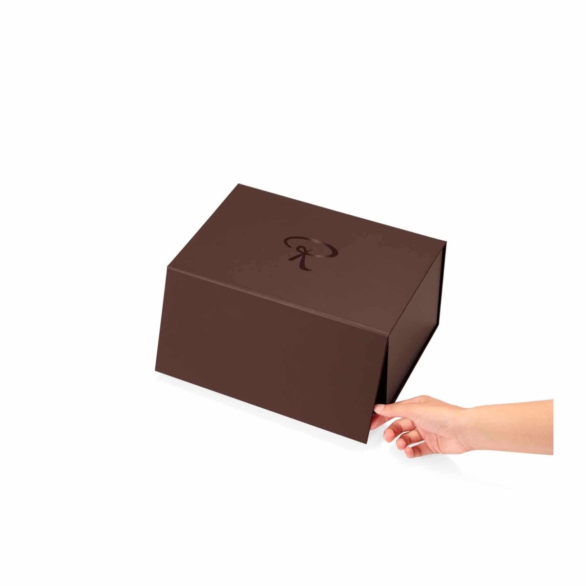 Braune Geschenkbox mit Rausch-Logo, elegant präsentiert, Hand greift zur Öffnung.