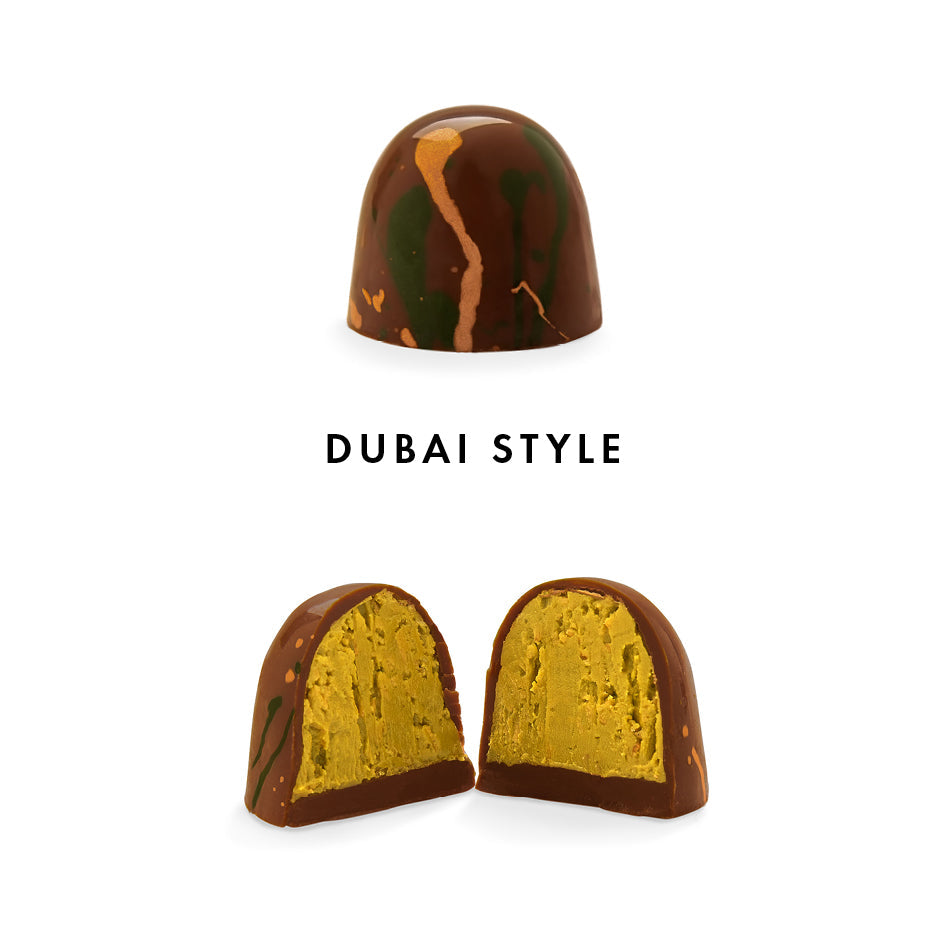 Glänzende Praline mit brauner Schokolade und bunten Spritzern, innen goldgelb gefüllt. - Rausch