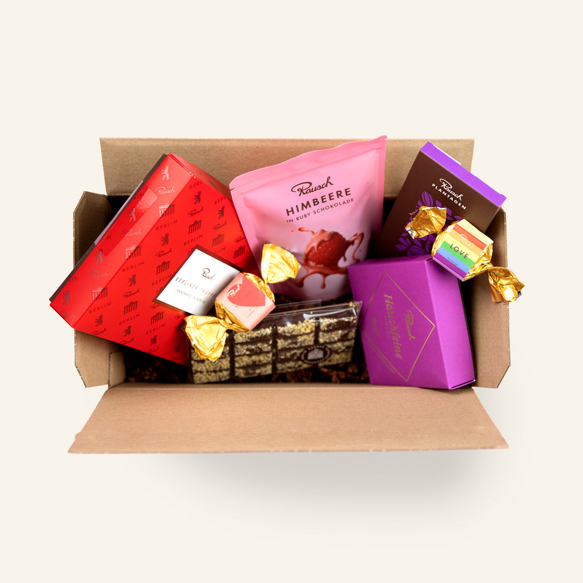 Offene Geschenkbox mit handwerklicher Schokolade und bunten Verpackungen. 